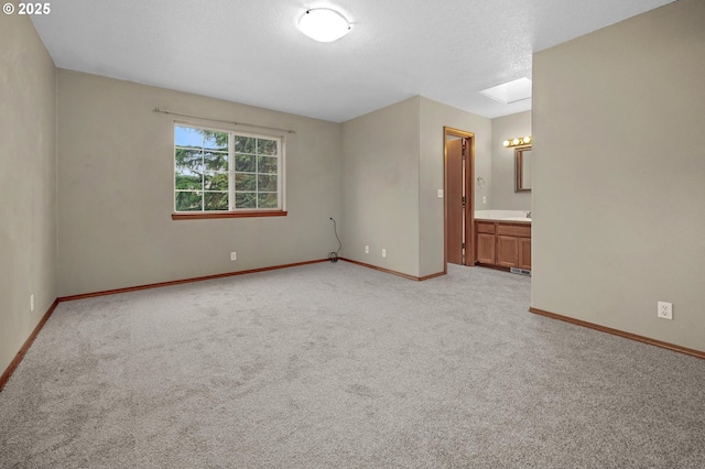 spare room with light colored carpet and a skylight