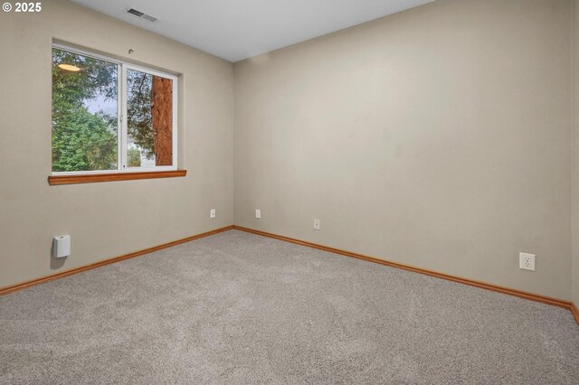 unfurnished room with visible vents, baseboards, and carpet