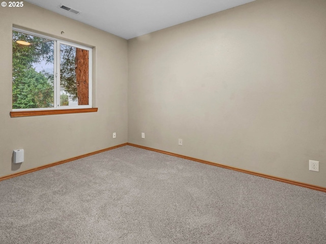 unfurnished room with visible vents, baseboards, and carpet floors