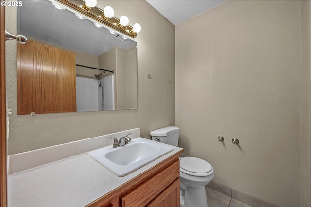 full bath featuring tile patterned flooring, a shower, toilet, and vanity