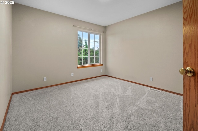 unfurnished room with visible vents, carpet floors, and baseboards