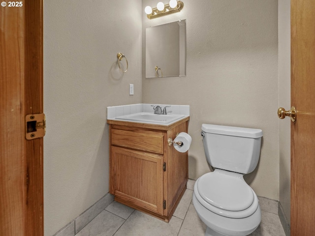 bathroom featuring toilet, vanity, and tile patterned flooring