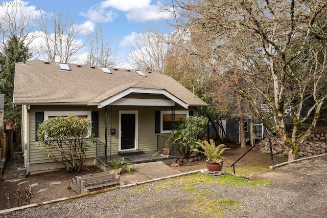 bungalow-style house with covered porch and roof with shingles