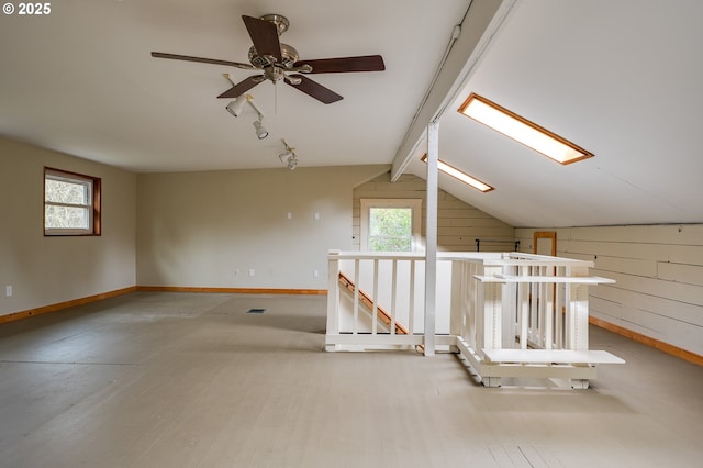 additional living space with plenty of natural light, vaulted ceiling with beams, baseboards, and wood finished floors