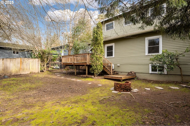 rear view of property with a fire pit, a deck, fence, and stairs