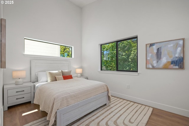 10729 NE Fremont St, Portland, OR 97220 - bedroom featuring multiple windows, wood finished floors, and baseboards
