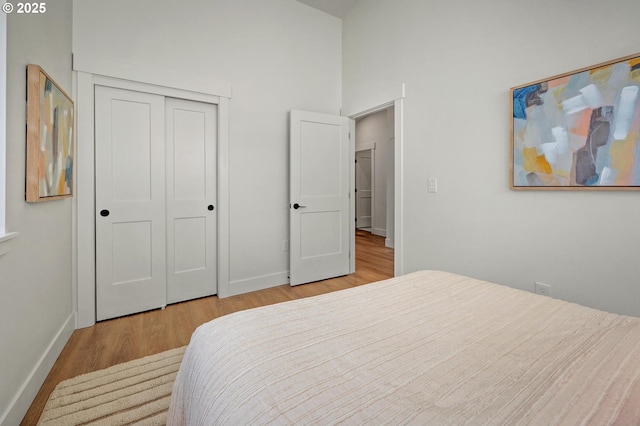 10729 NE Fremont St, Portland, OR 97220 - bedroom with wood finished floors, baseboards, a closet, and high vaulted ceiling