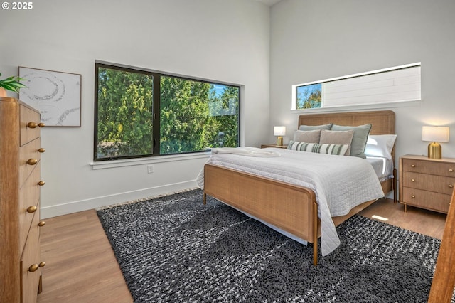 10729 NE Fremont St, Portland, OR 97220 - bedroom with wood finished floors, baseboards, and a high ceiling