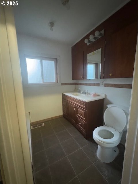 bathroom featuring vanity, toilet, and tile patterned flooring