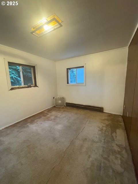 interior space with carpet floors and baseboard heating