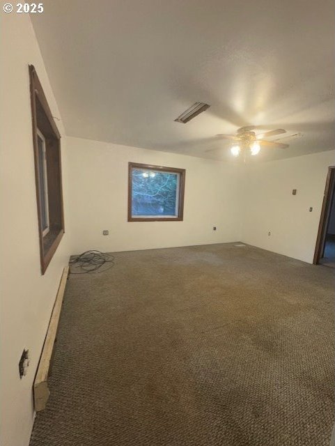 carpeted spare room featuring ceiling fan and baseboard heating