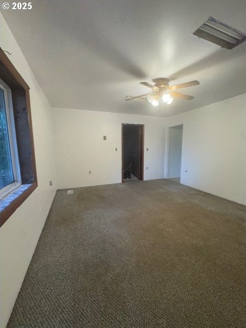 carpeted spare room featuring ceiling fan