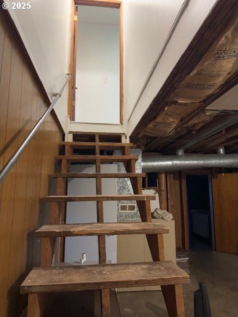 stairway with wooden walls and concrete floors