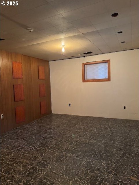 basement featuring wooden walls