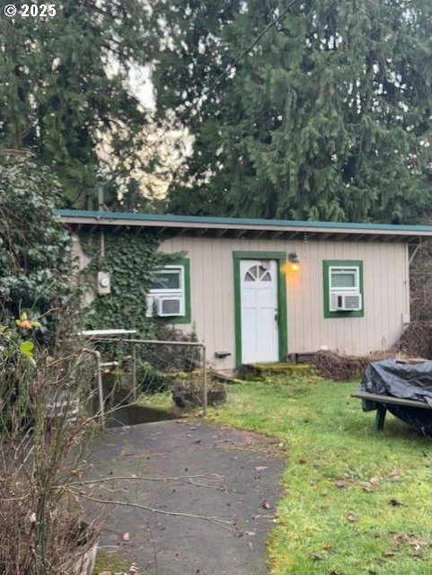 view of outbuilding featuring cooling unit and a yard