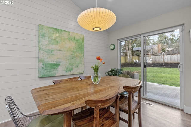 dining room with wood walls and wood-type flooring