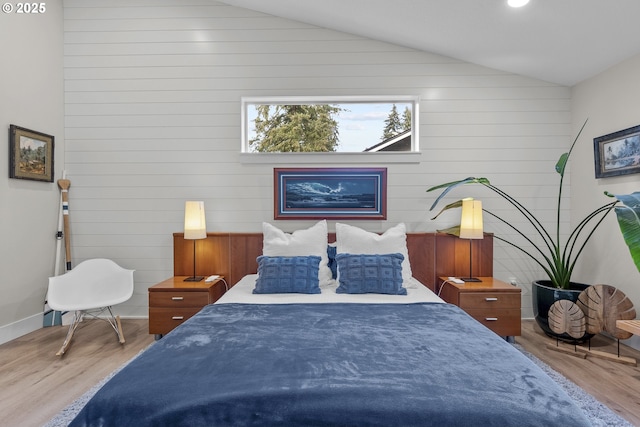 bedroom featuring light hardwood / wood-style flooring and lofted ceiling