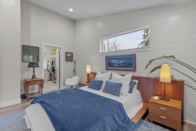 bedroom with a closet, light hardwood / wood-style floors, and a walk in closet