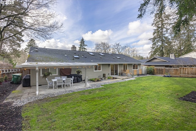 rear view of house with a patio area and a lawn