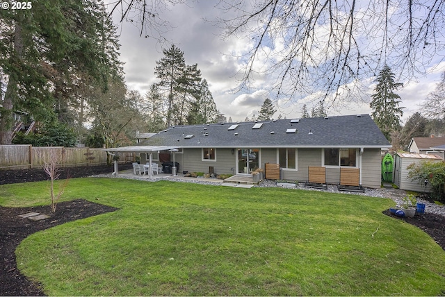 back of property with a storage unit, a lawn, and a patio area