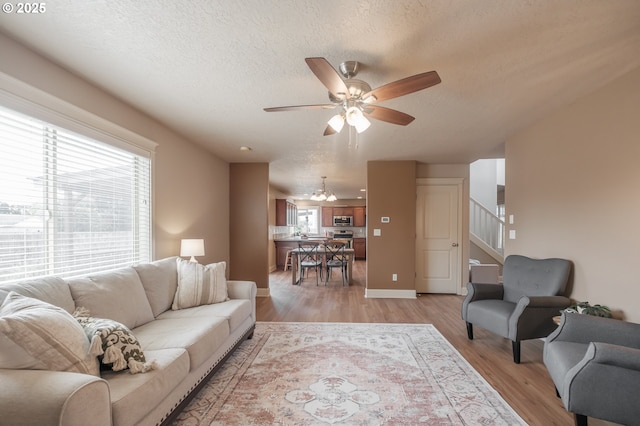 1989 S 12th St, Lebanon, OR 97355 - living area with a ceiling fan, stairway, a textured ceiling, and light wood-style floors