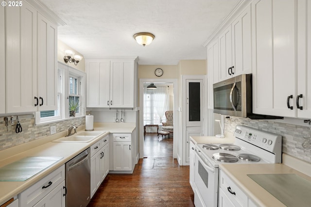 kitchen featuring dark wood-type flooring, a sink, white cabinetry, light countertops, and appliances with stainless steel finishes