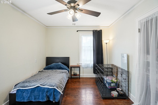 bedroom with ornamental molding, dark wood-style flooring, a ceiling fan, and baseboards