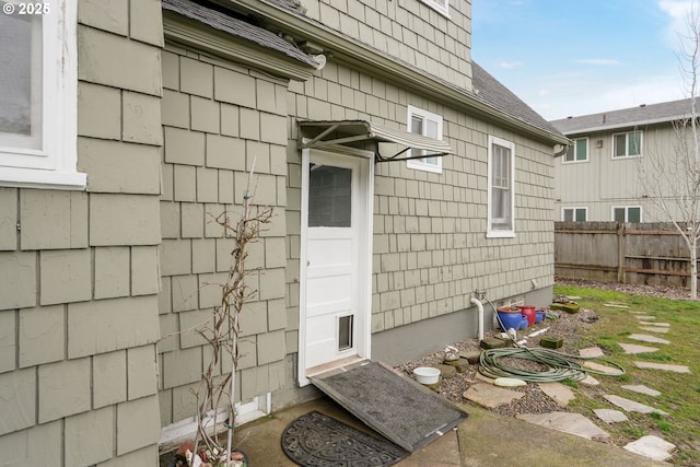 view of exterior entry featuring fence