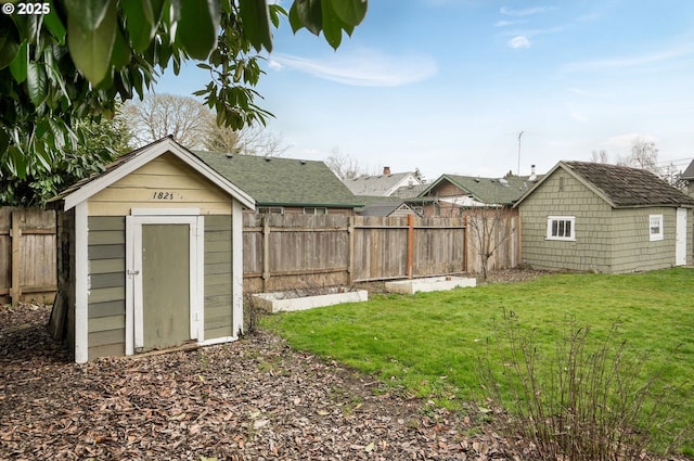 view of yard featuring a shed, a fenced backyard, and an outdoor structure