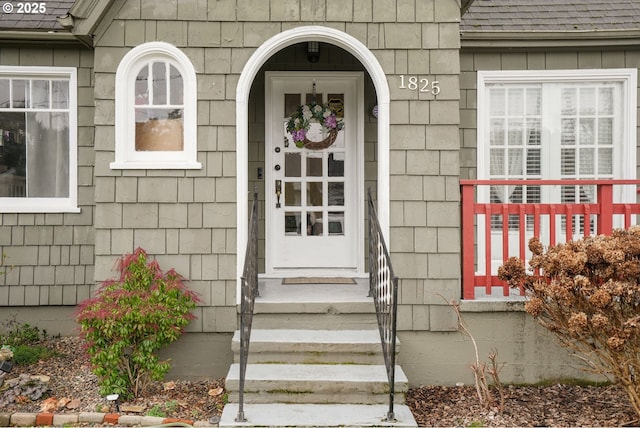 doorway to property featuring a shingled roof