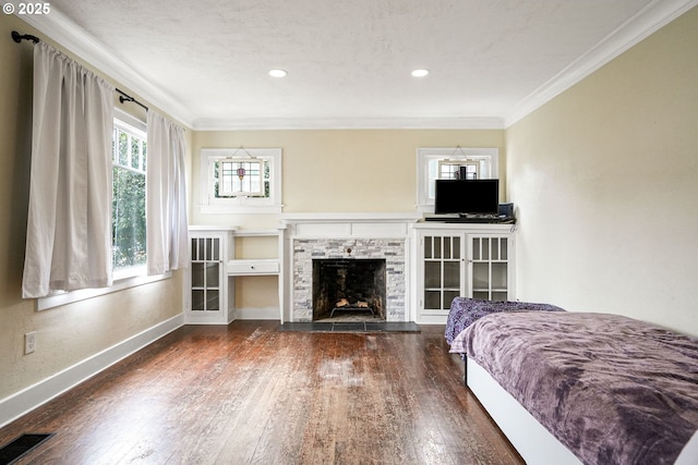 bedroom featuring baseboards, visible vents, dark wood finished floors, and ornamental molding