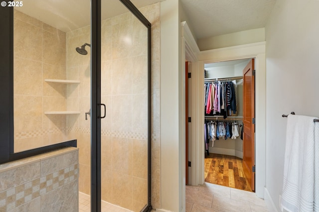 1046 NW Deerfern Loop, Camas, WA 98607 - full bathroom featuring tile patterned floors, a shower stall, and a walk in closet
