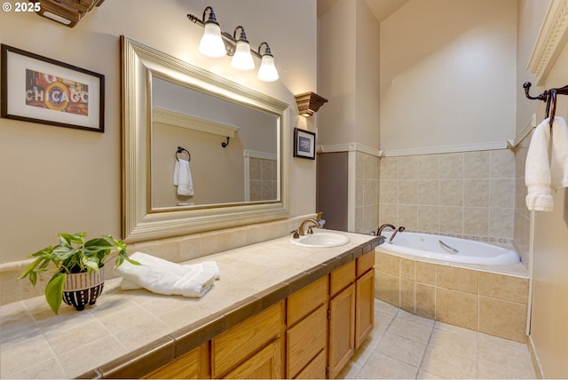 bathroom featuring tile patterned floors, tiled bath, and vanity