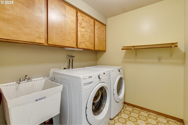 laundry room with cabinets, washing machine and dryer, and sink