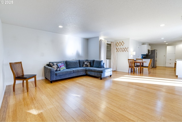 living room with light wood-type flooring and a textured ceiling