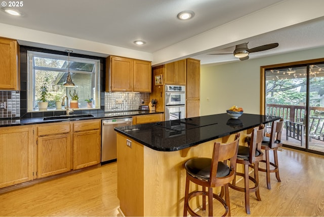 kitchen featuring pendant lighting, sink, a breakfast bar area, a center island, and stainless steel appliances