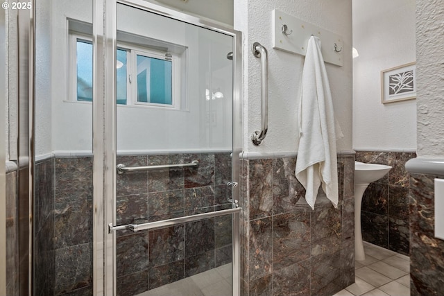 3110 NW Monte Vista Ter, Portland, OR 97210 - full bathroom with tile patterned flooring, a stall shower, a wainscoted wall, and tile walls