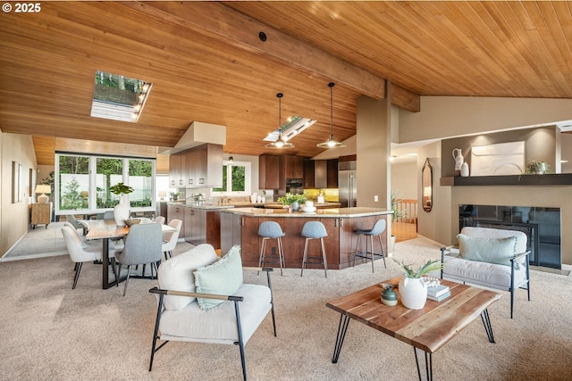 3110 NW Monte Vista Ter, Portland, OR 97210 - living area with vaulted ceiling with beams, a glass covered fireplace, wooden ceiling, and light colored carpet
