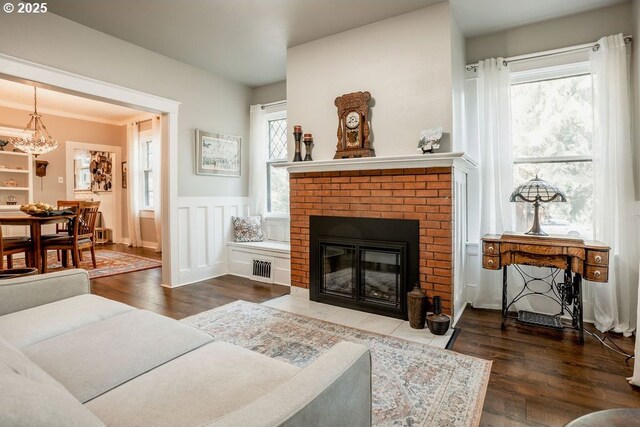 301 W Walnut St, Winlock, WA 98596 - living area featuring wood finished floors, a fireplace, wainscoting, and a chandelier