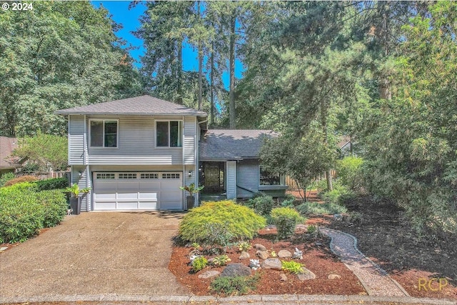 split level home featuring concrete driveway and an attached garage