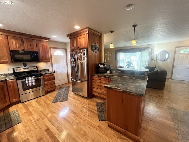 405 1st St, La Grande, OR 97850 - kitchen featuring stainless steel appliances, a textured ceiling, a peninsula, brown cabinets, and recessed lighting