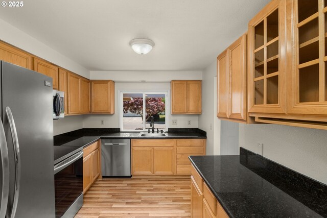 2235 SE Willow Ct, Hillsboro, OR 97123 - kitchen with appliances with stainless steel finishes, light wood-style flooring, glass insert cabinets, and dark stone counters