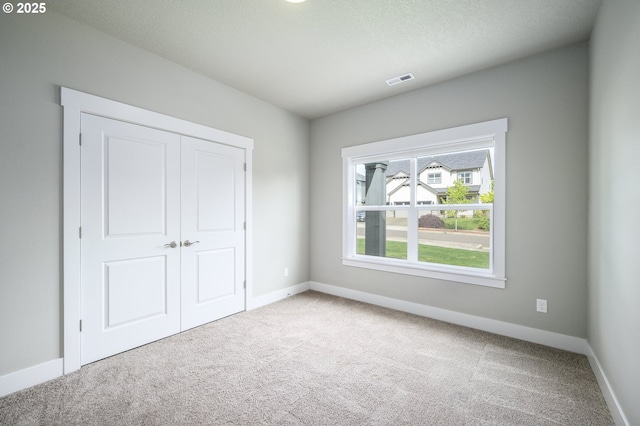 unfurnished bedroom featuring carpet flooring and baseboards