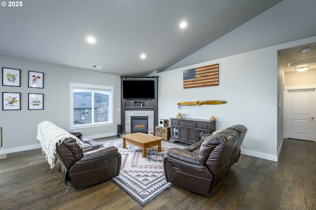 living area featuring baseboards, wood finished floors, recessed lighting, a tile fireplace, and vaulted ceiling