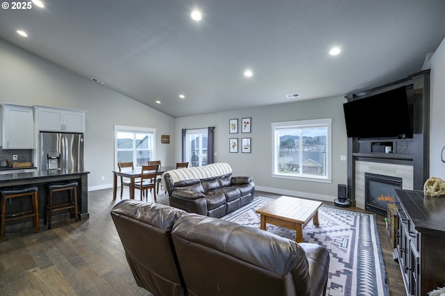 living area with lofted ceiling, recessed lighting, dark wood-type flooring, baseboards, and a fireplace