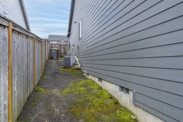view of side of property featuring fence and central air condition unit