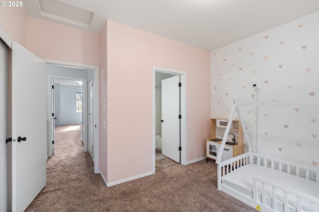 carpeted bedroom featuring attic access and baseboards