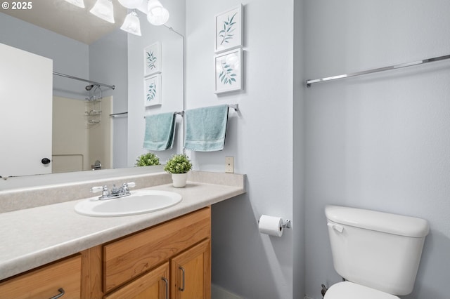 bathroom featuring a shower, toilet, and vanity