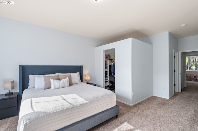 bedroom with baseboards, carpet floors, a closet, and a walk in closet