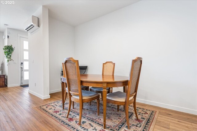 16615 SE Sunshower Pl, Happy Valley, OR 97086 - dining space featuring a wall unit AC, light wood-style floors, and baseboards